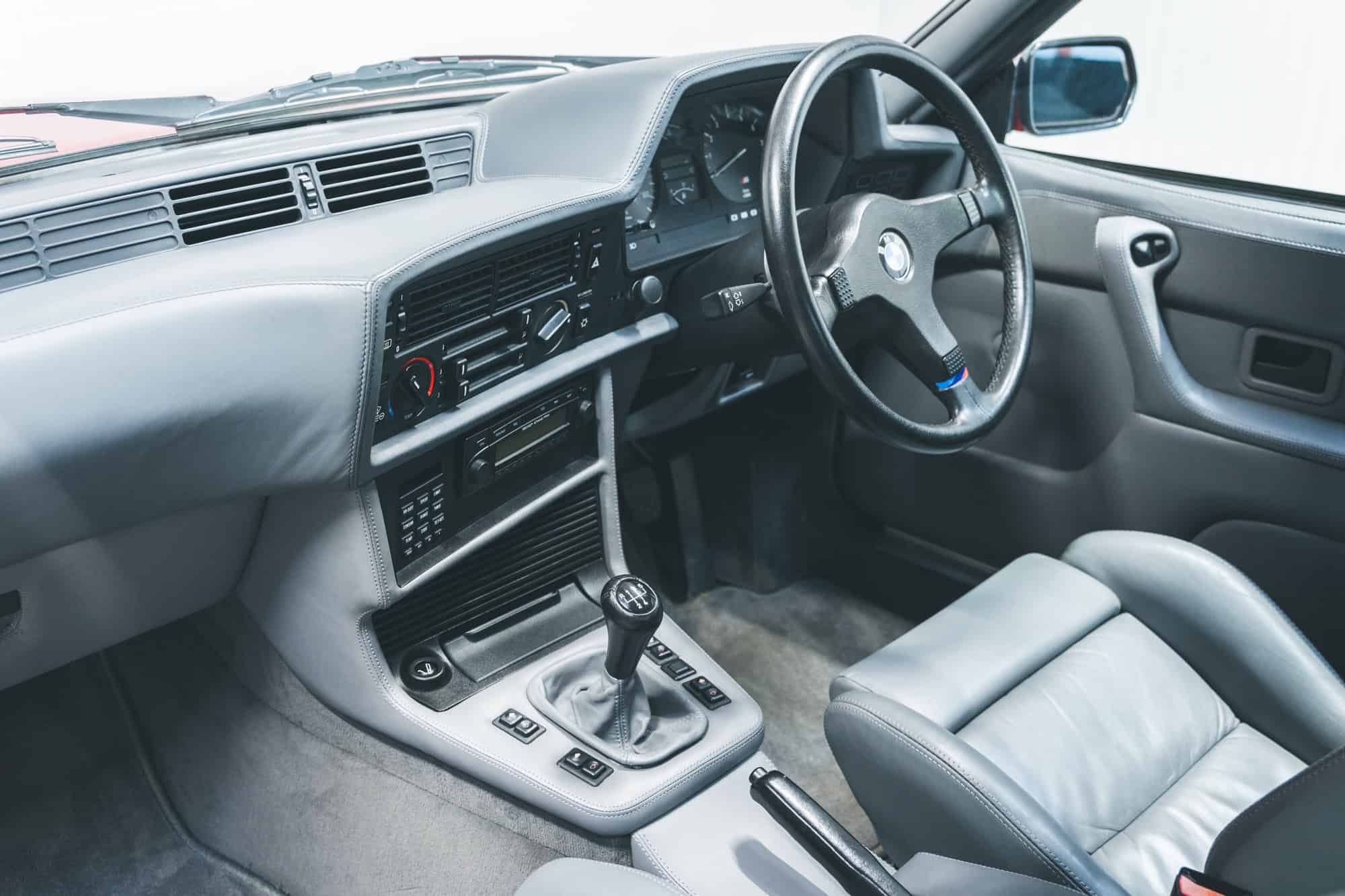 Interior and silver leather of E24 M635 Highline CSL steering wheel and manual transmission.