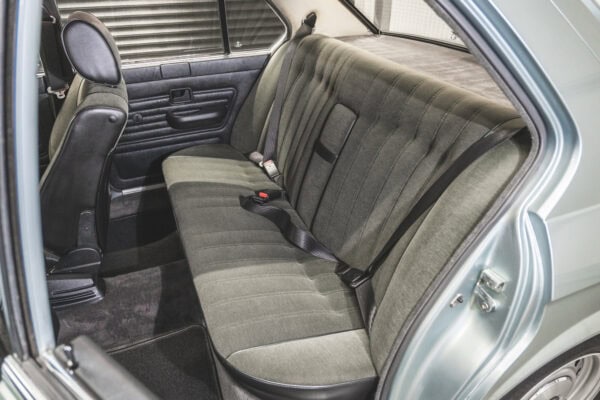 Passenger side view of a BMW E28 525 Eta rear passenger seat in anthracite cloth and centre armrest.