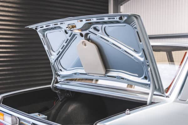 Rear quarter view of a BMW E28 525 with a rust free boot lid and original tool kit.