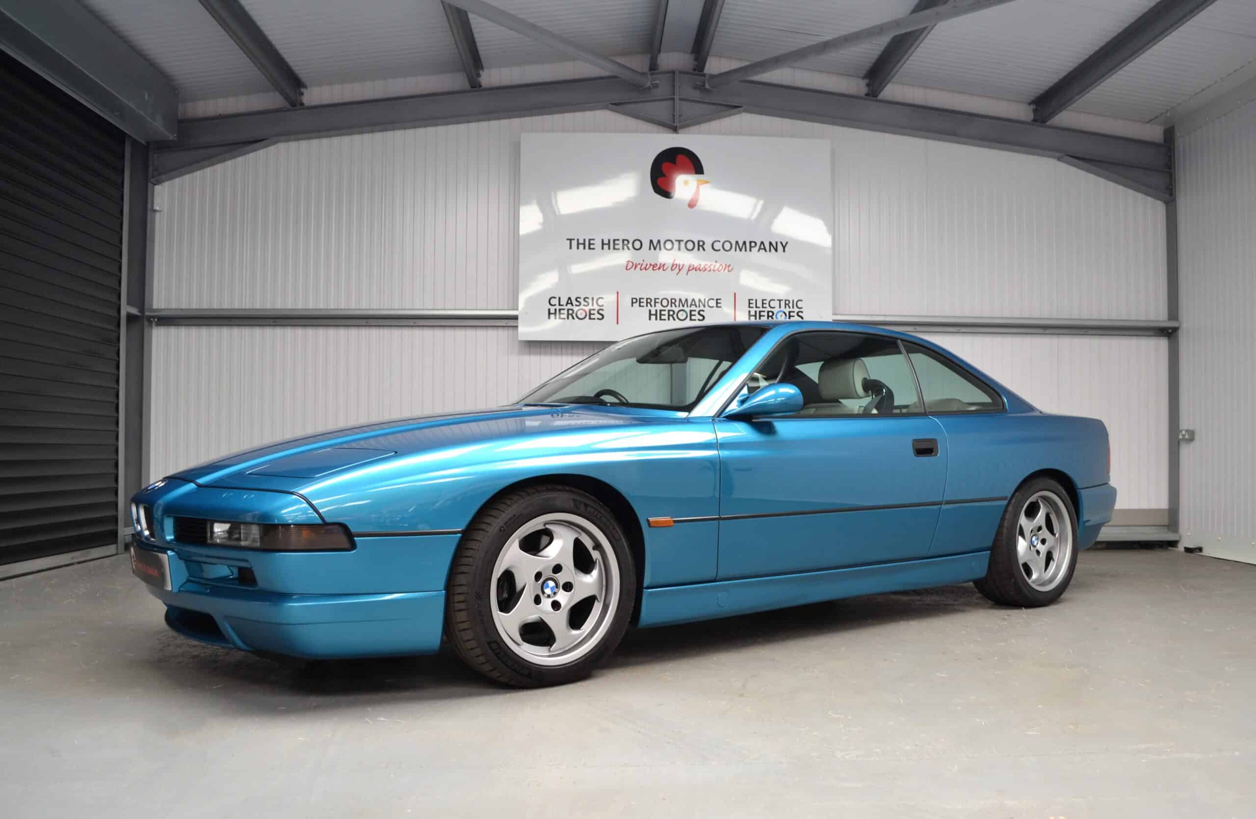 Nearside angle of a BMW E31 840ci with white leather interior and Atlantis Blue paint.