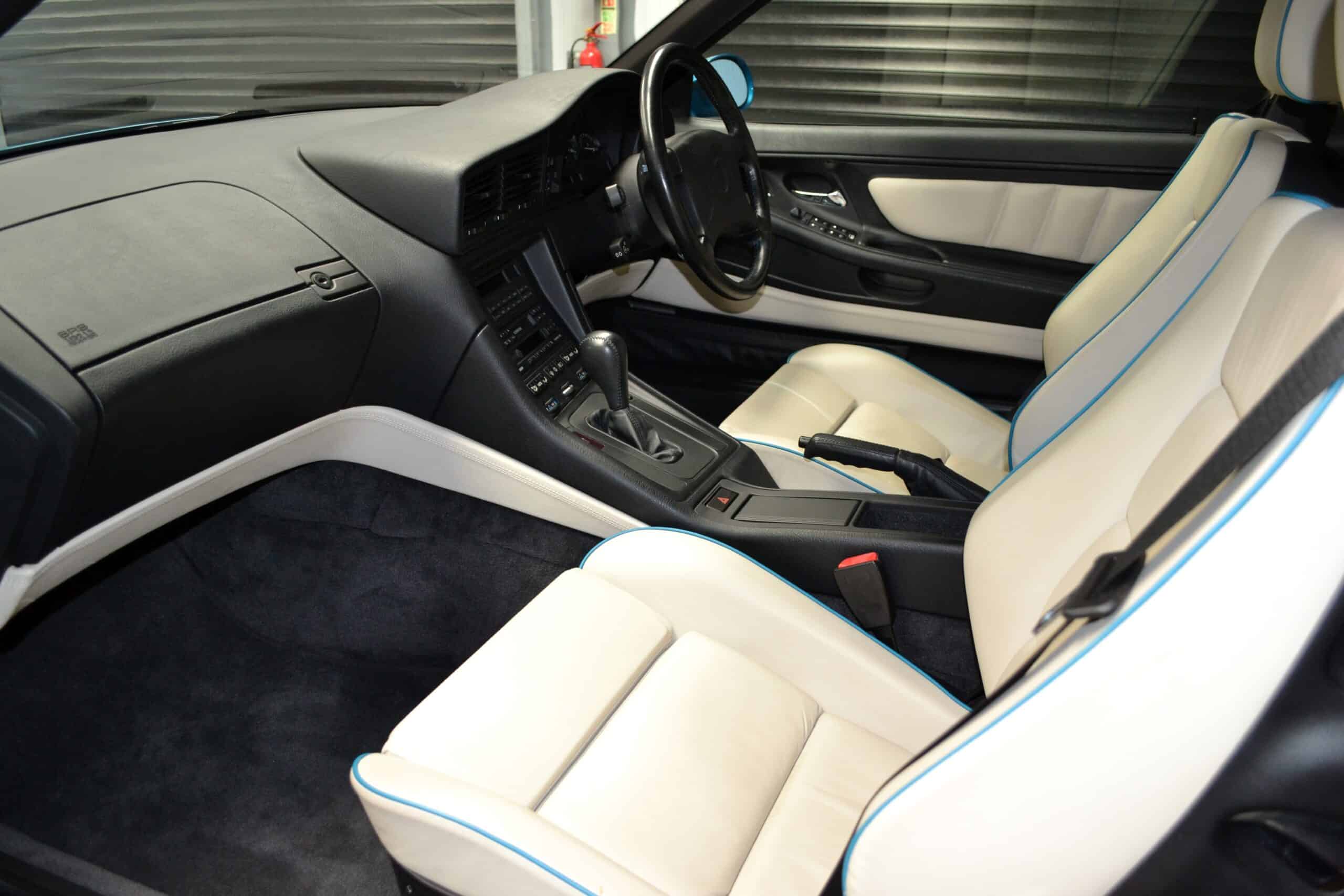 Lotus white leather interior with Atlantis blue piping on an E31 840ci and black M sport steering wheel.