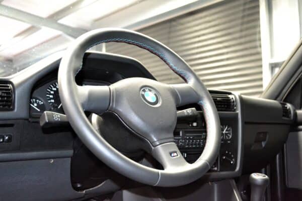 BMW E30 320is instrument cluster and Black leather M sport steering wheel.