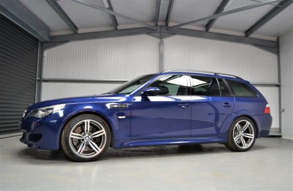 Nearside exterior of E61 M5 in Interlagos Blue with 19 inch M sport wheels and Xenon lights.