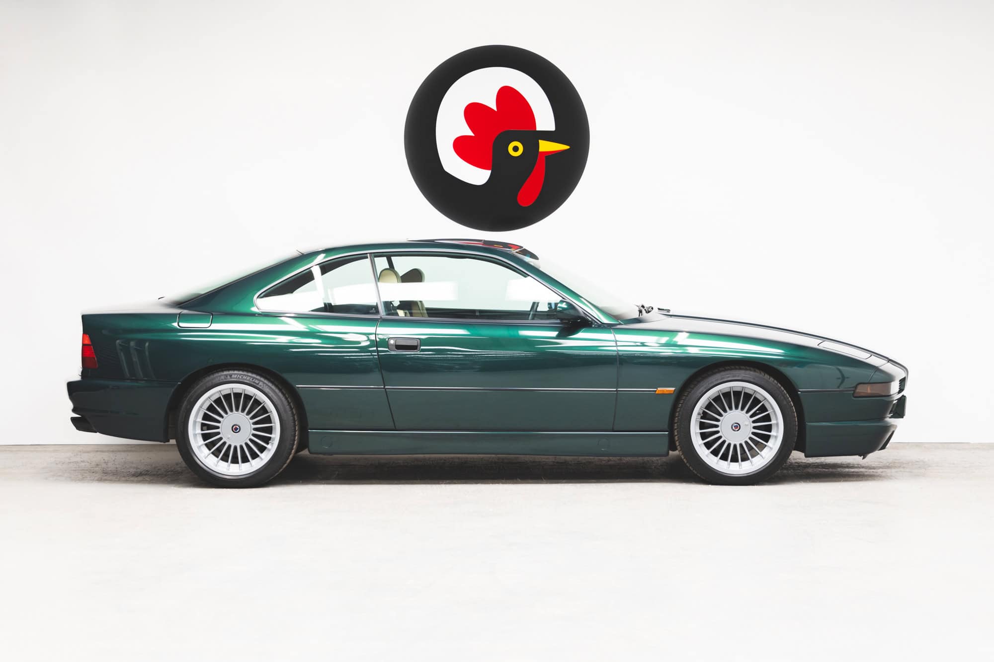 Side on view of a BMW E31 840 Ci sport coupe pop up headlights with 18" Alpina Alloy Wheels.