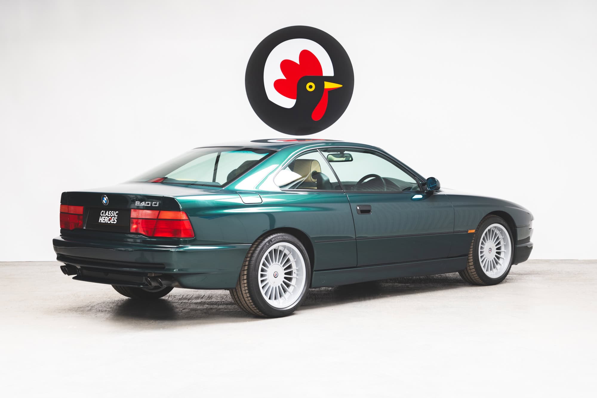 Offside rear quarter view of a BMW E31 840 Ci sport coupe in Individual Fern Green Metallic on 18