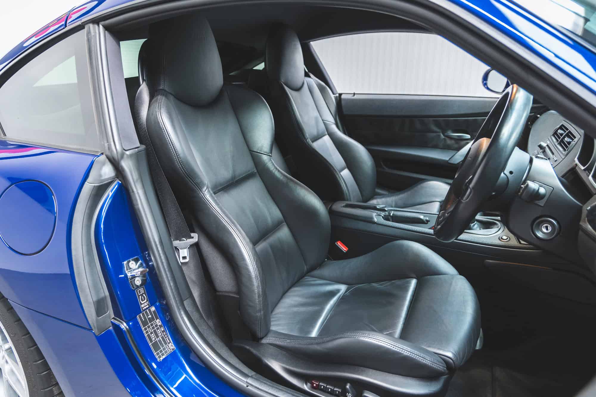 Offside interior view of BMW E86 Z4 M Coupe showing black leather interior and steering wheel.