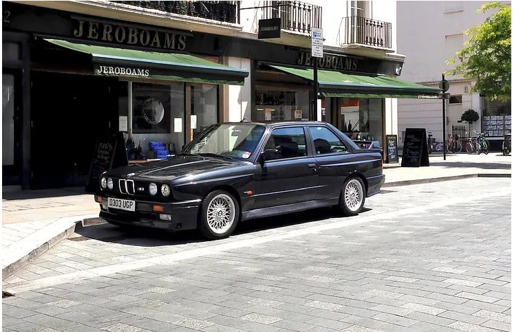 Offside exterior of Black M3 with alloy wheels.