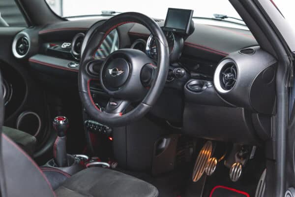 Internal view on centre console dashboard and 3 spoke sport leather steering wheel.