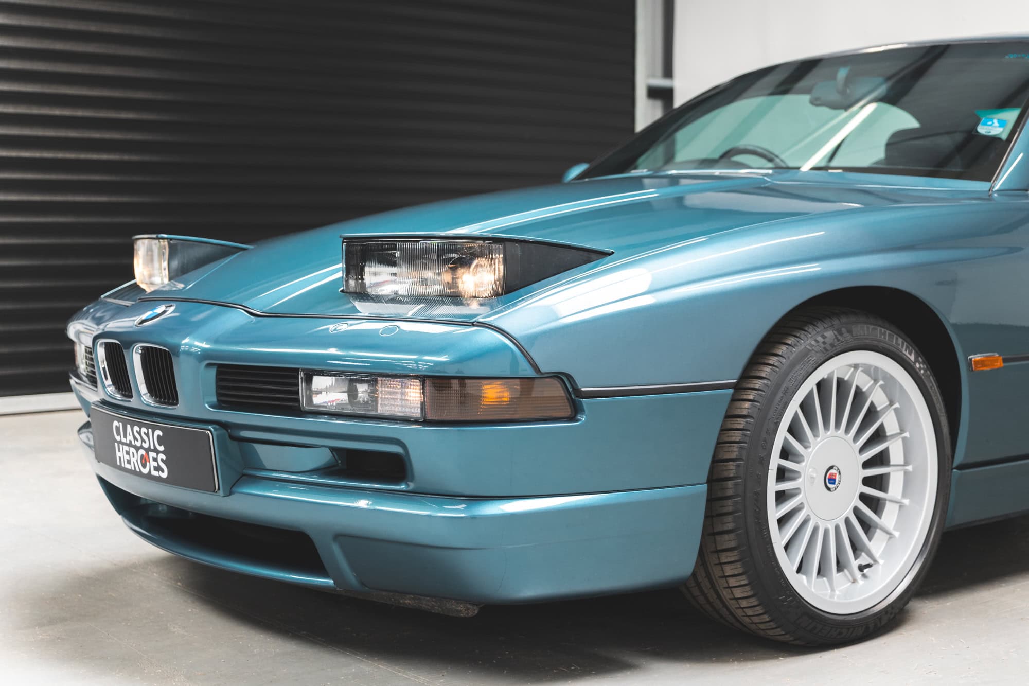 Nearside exterior of bonnet and raised headlights on BMW E31 850CSI in Barbados Green.