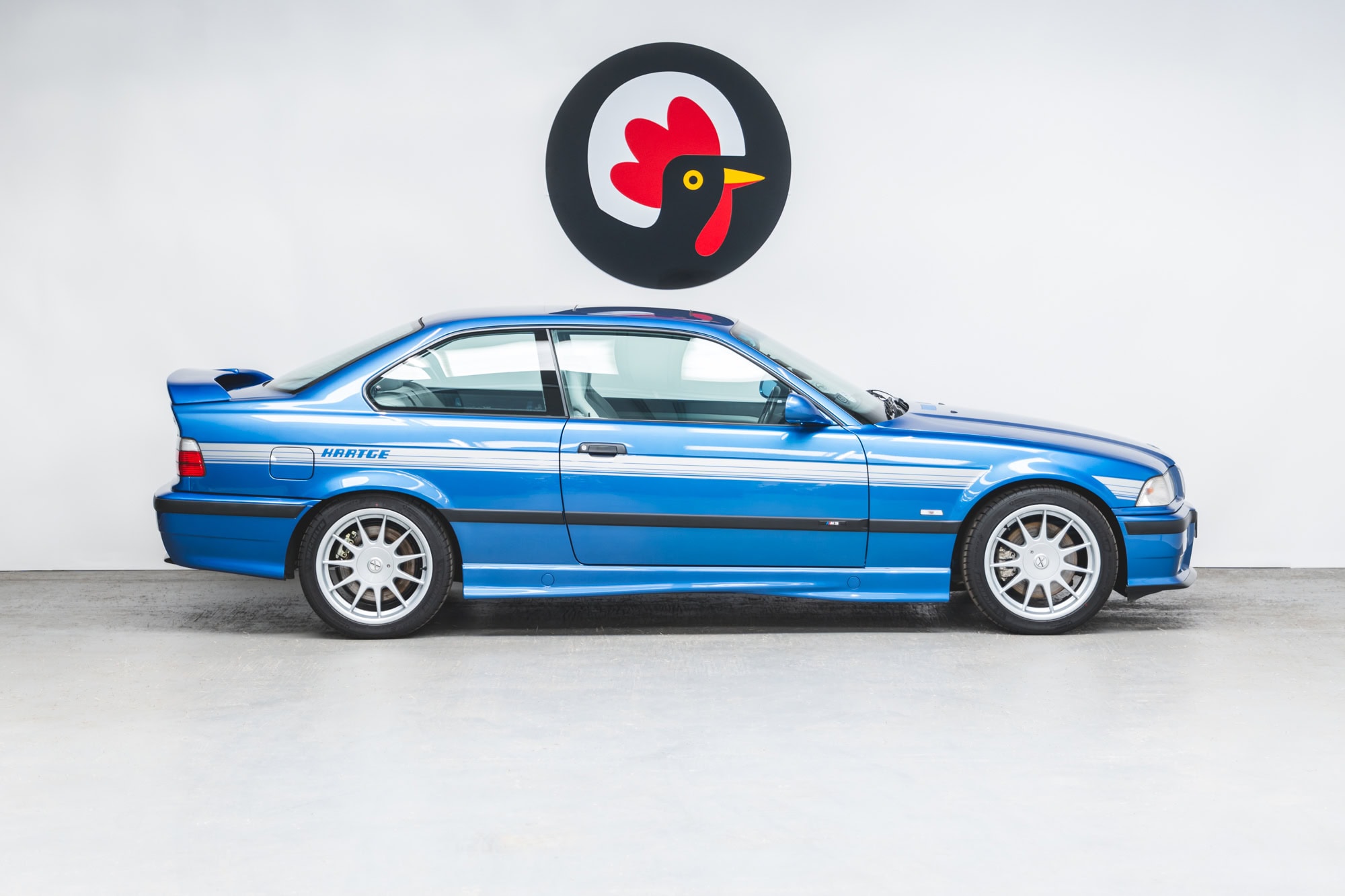 Offside exterior showing boot spoiler alloy wheels and silver stripes on BMW E36 M3 Hartge Estoril Blue Coupe.