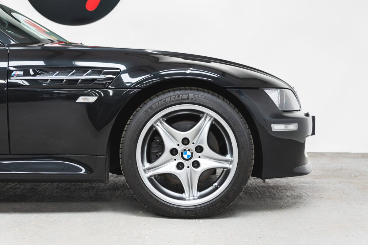 Front quarter panel of BMW E36 Z3 M Coupe Sapphire Black showing alloy wheels.