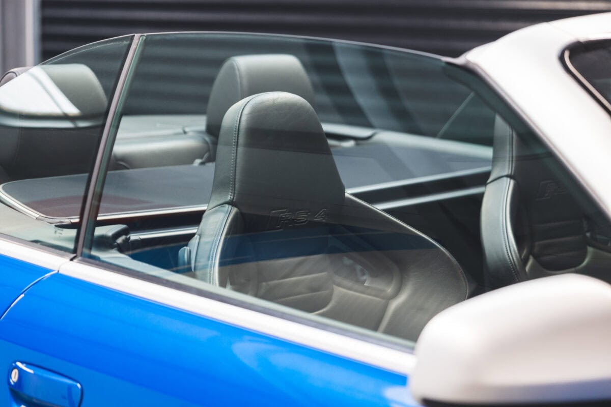 Offside window and black leather interior of Audi RS4 B7 Cabriolet Sprint Blue Supercharged.