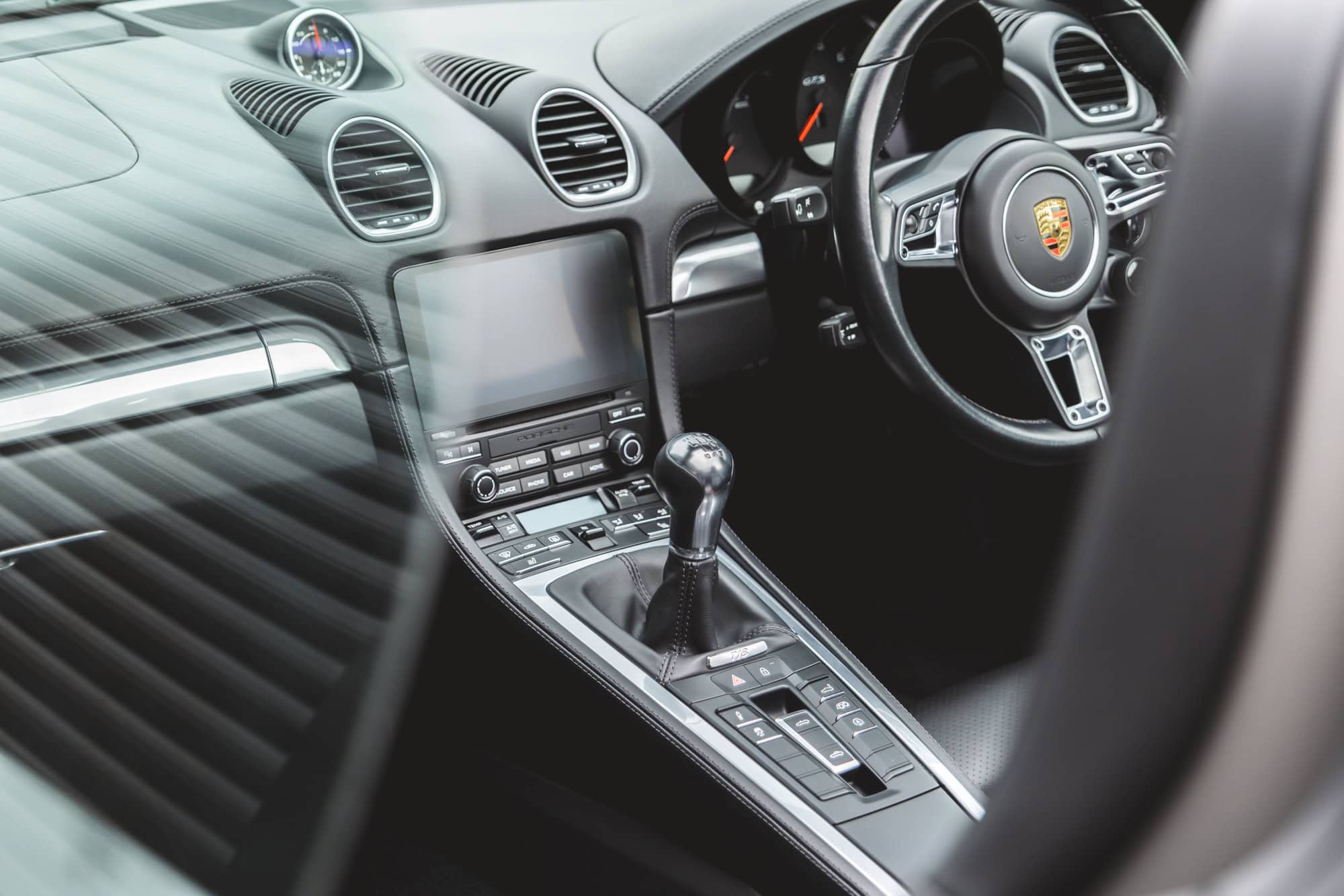 Centre console and steering wheel on Porsche Boxster 718 Spyder GTS Python Green.