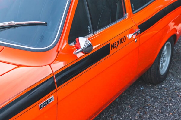 A Mk 1 Ford Escort Mexico GT in orange with mini lite alloy wheels and a black stripe