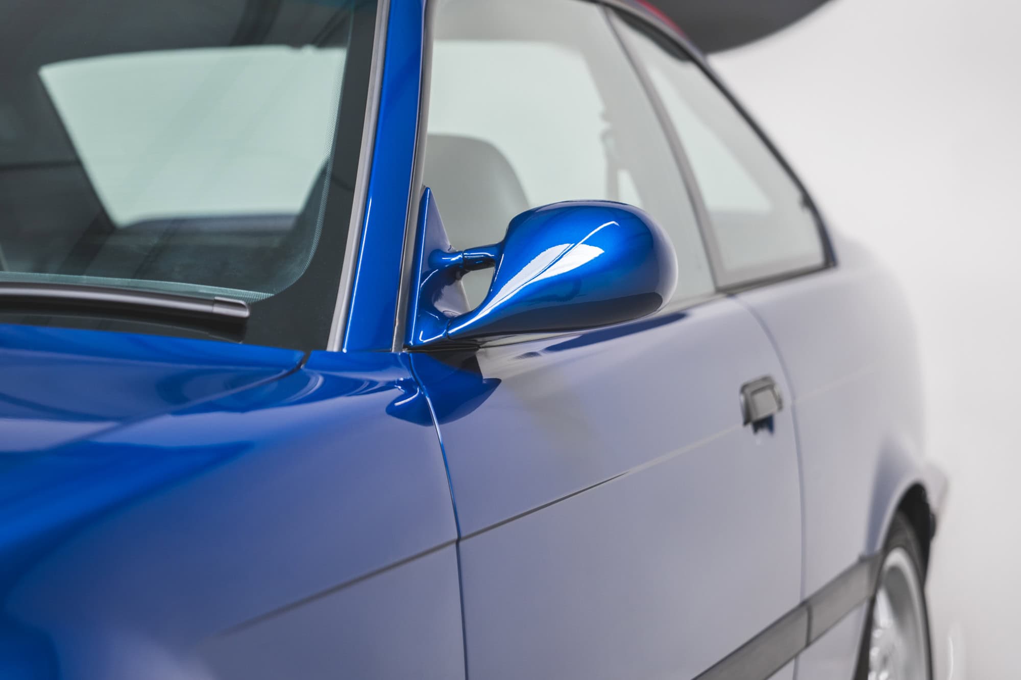 Nearside wing mirror and door on BMW E36 M3 Avus Blue Metallic.