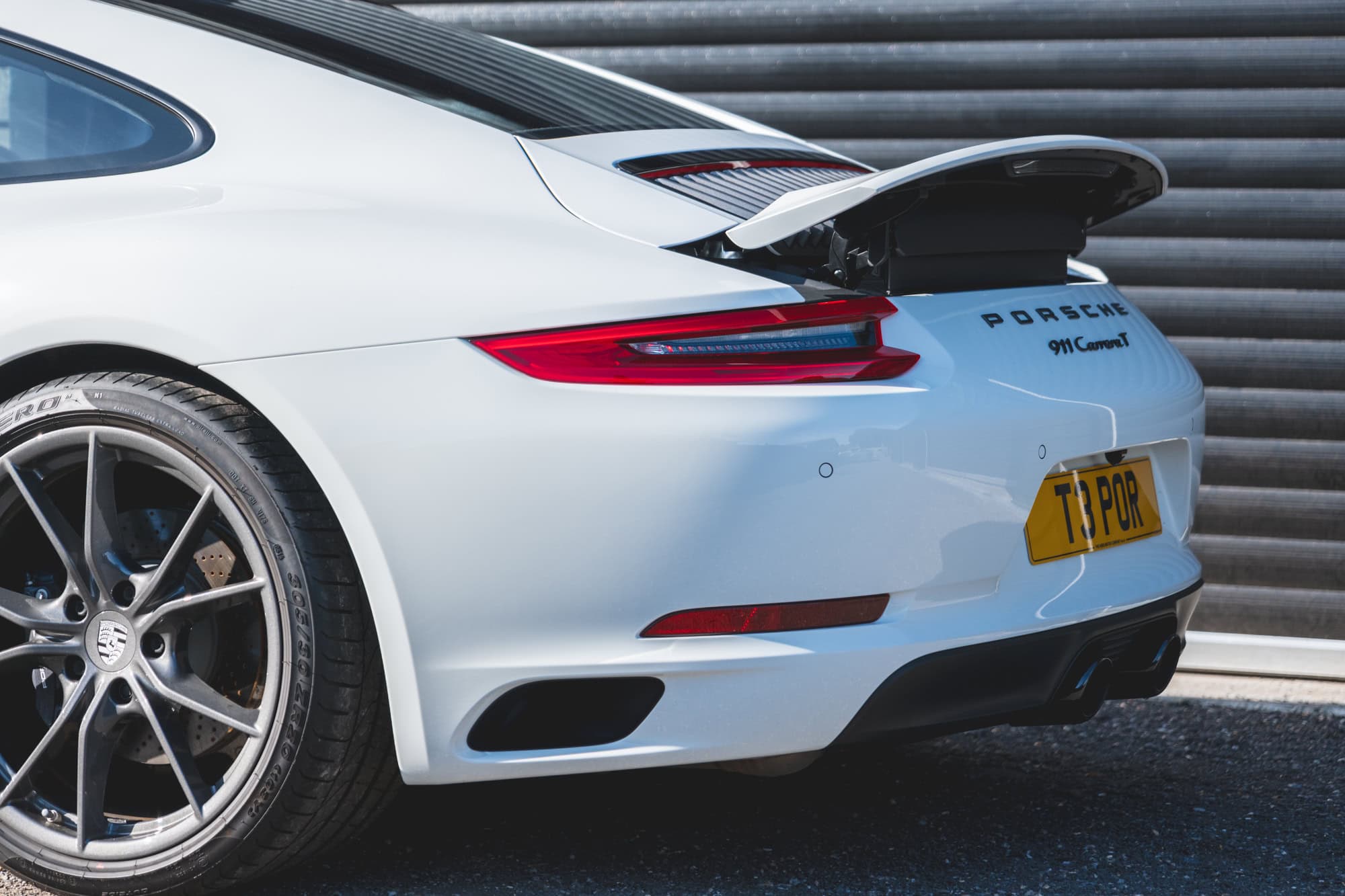 Alloy wheel and rear spoiler on Pure White Porsche 991 Carrera.
