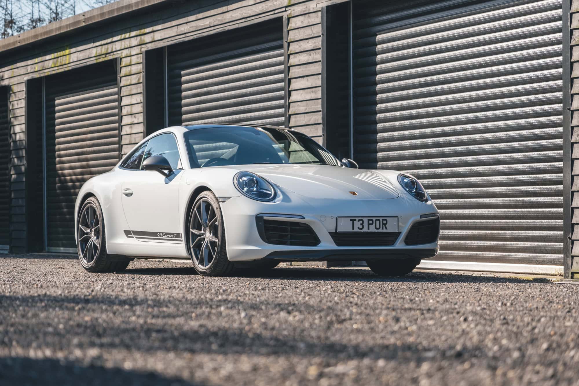 Front offside exterior of Pure White Porsche 991 Carrera T showing alloy wheels.