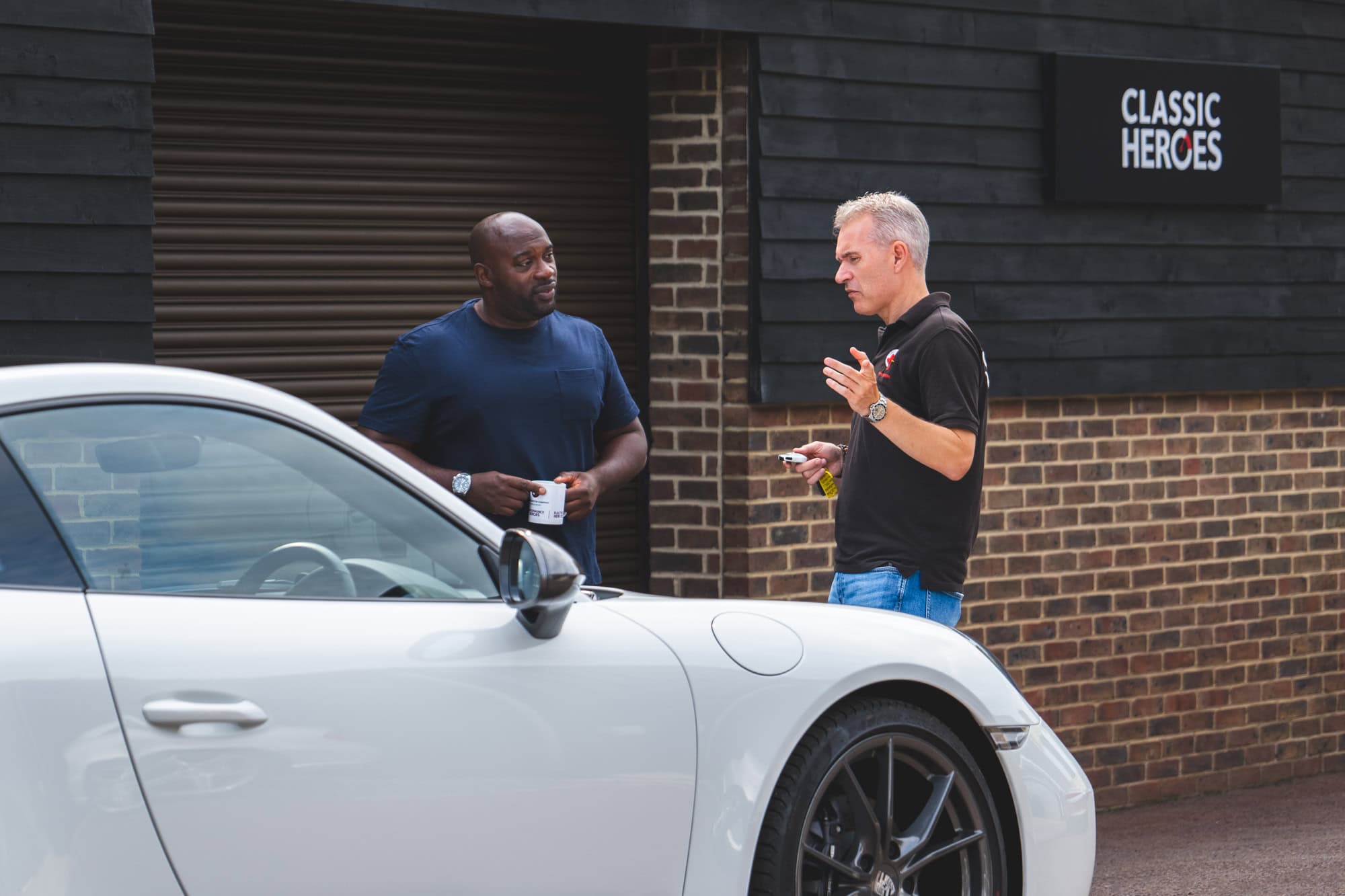 Jack talks with a customer next to a white Porsche 991 Carrera T.