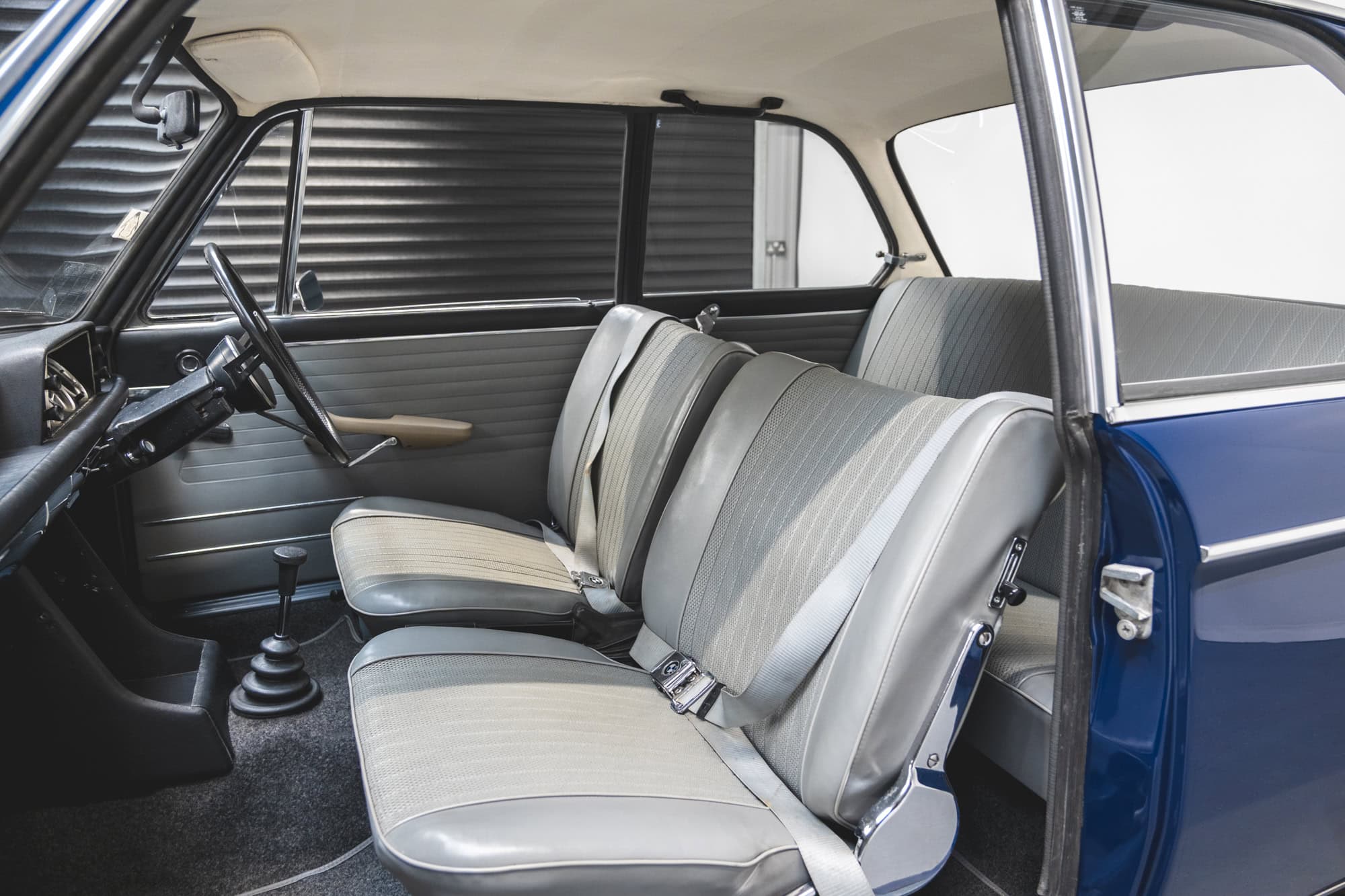 Nearside interior showing steering wheel and gear stick on BMW 2002 1968 Pacific Blue.