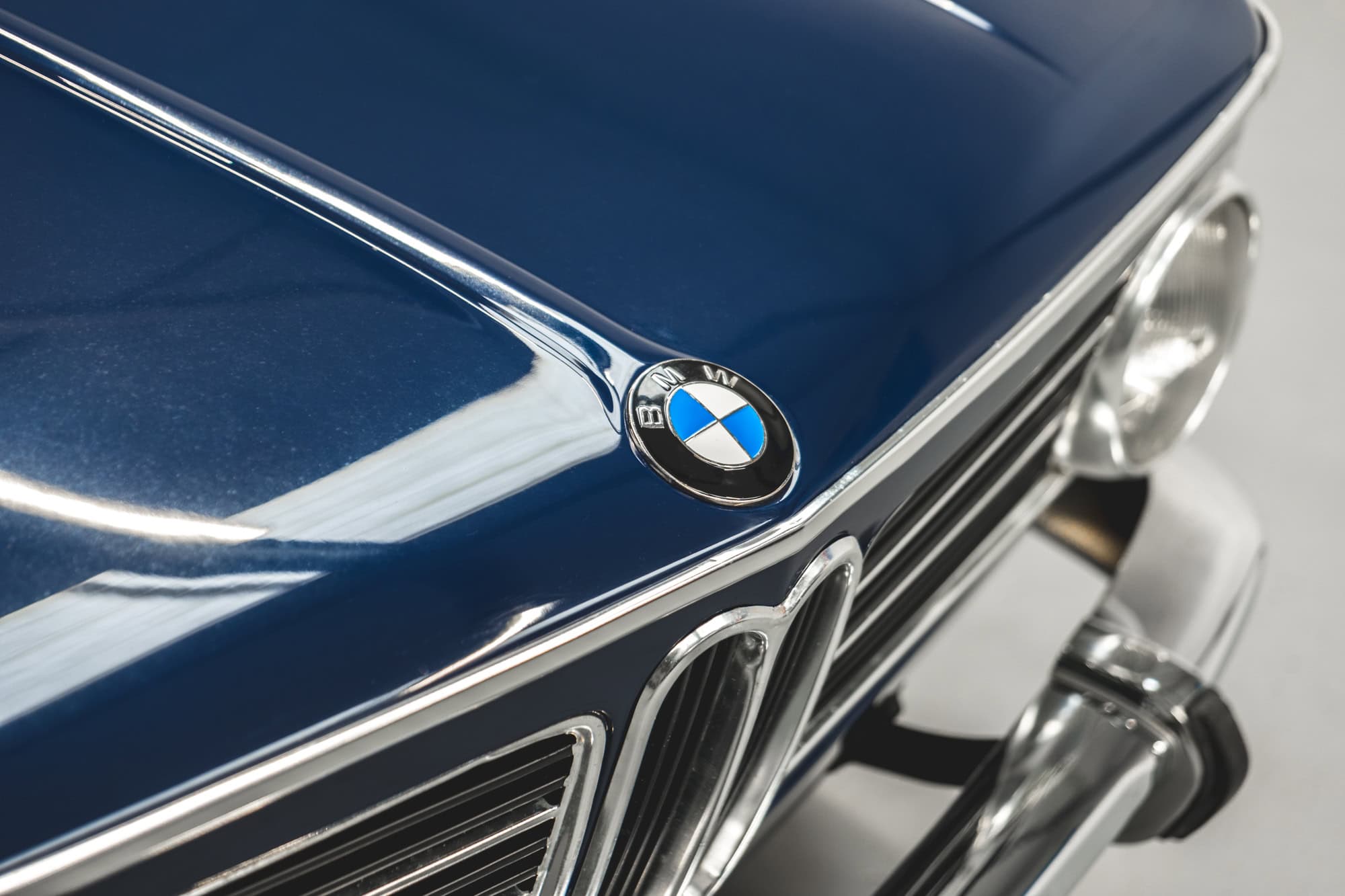 Close up exterior view of BMW badge on bonnet and front grill on BMW 2002 1968 Pacific Blue.