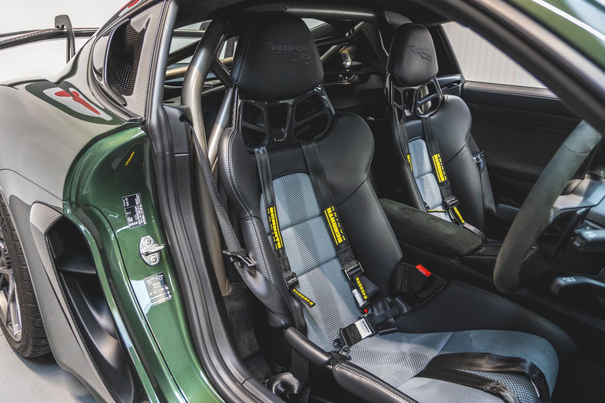 Offside interior showing carbon fibre bucket seats and safety harness.