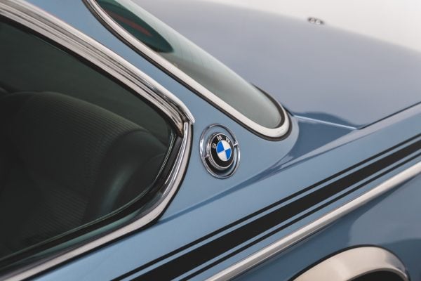 Rear quarter window on BMW 3.0 E9 CSL Fjord Blue showing BMW badge and chrome trim.