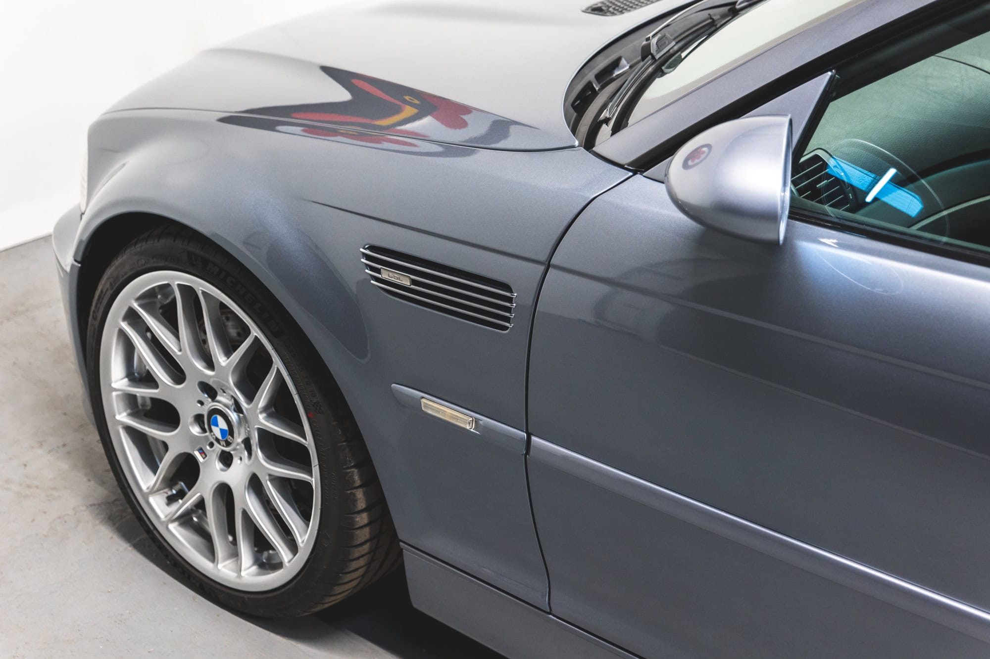 Front quarter detail shot of the front quarter and 19" alloy wheel of a silbergrau BMW E46 M3.