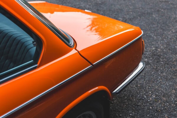 Boot lid and chrome trim on BMW 2002 tii Inka Orange.