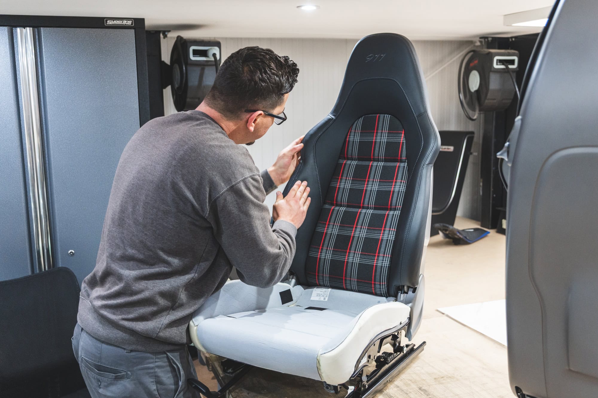 A skilled trimmer recovers a Recaro Porsche seat.