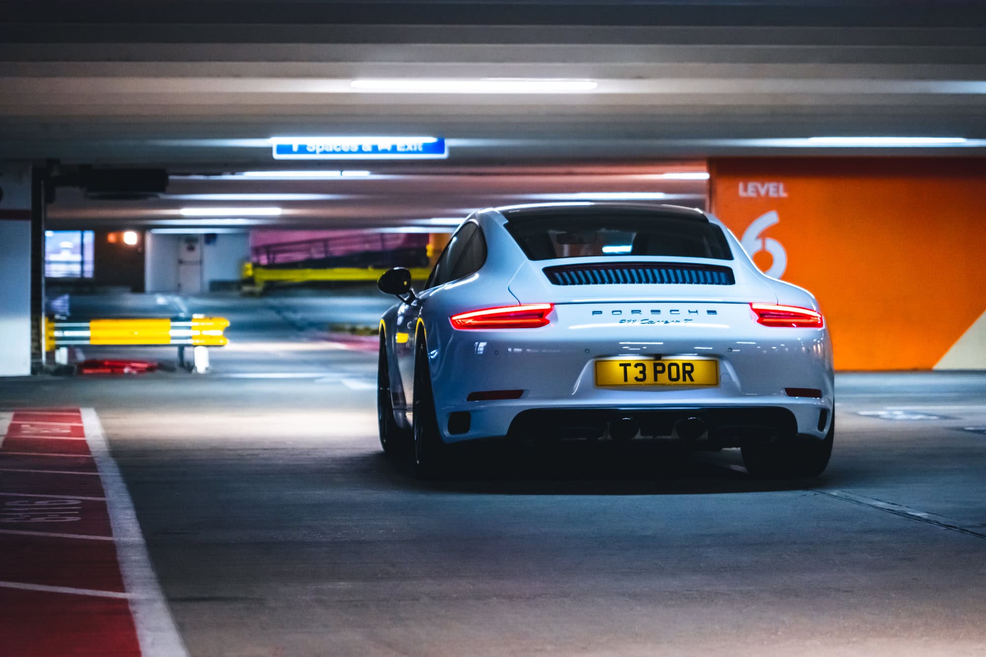 A Porsche 991 Carrera T under neon lights.