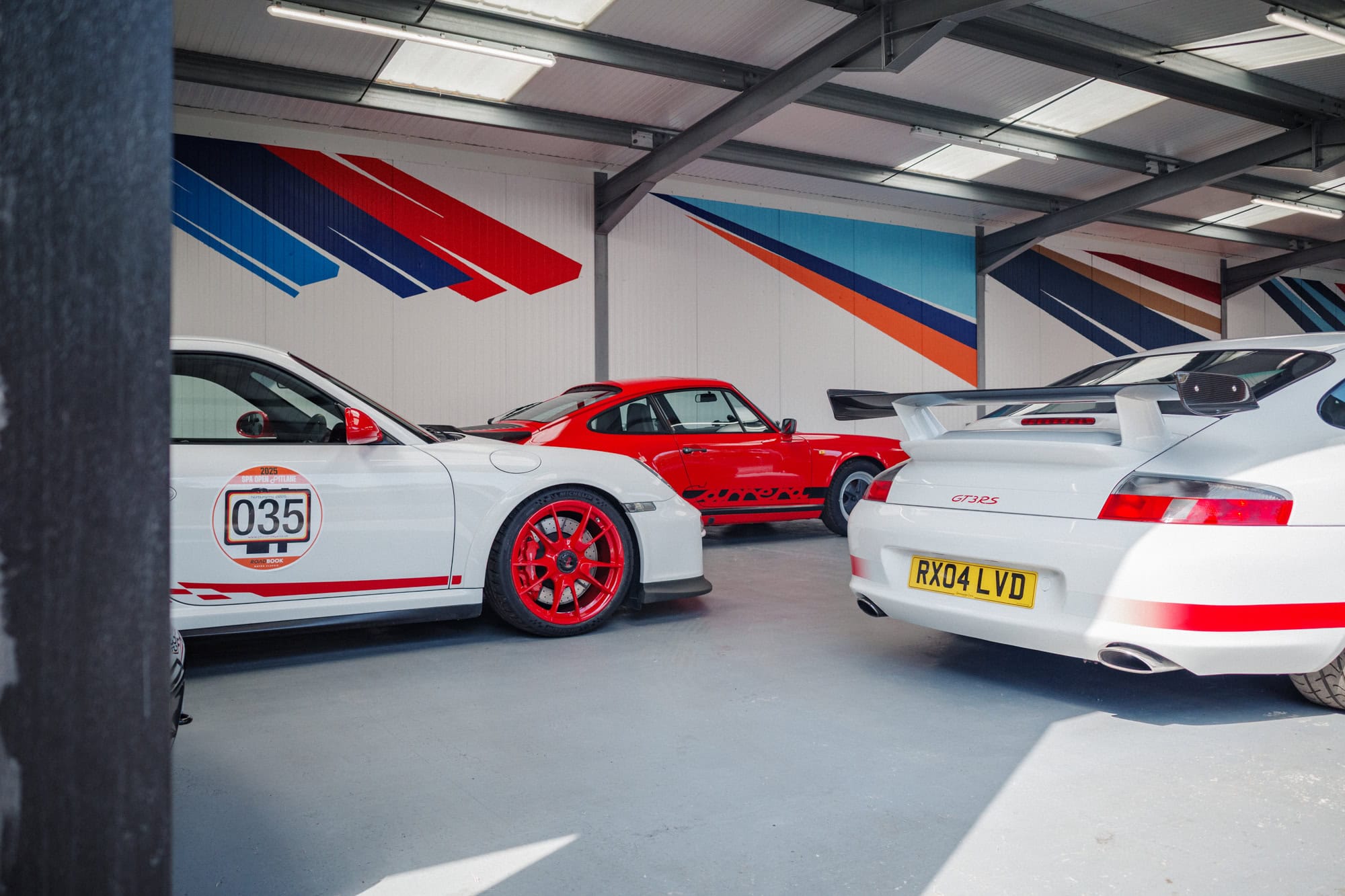 Three Porsches 911 in a car storage unit.
