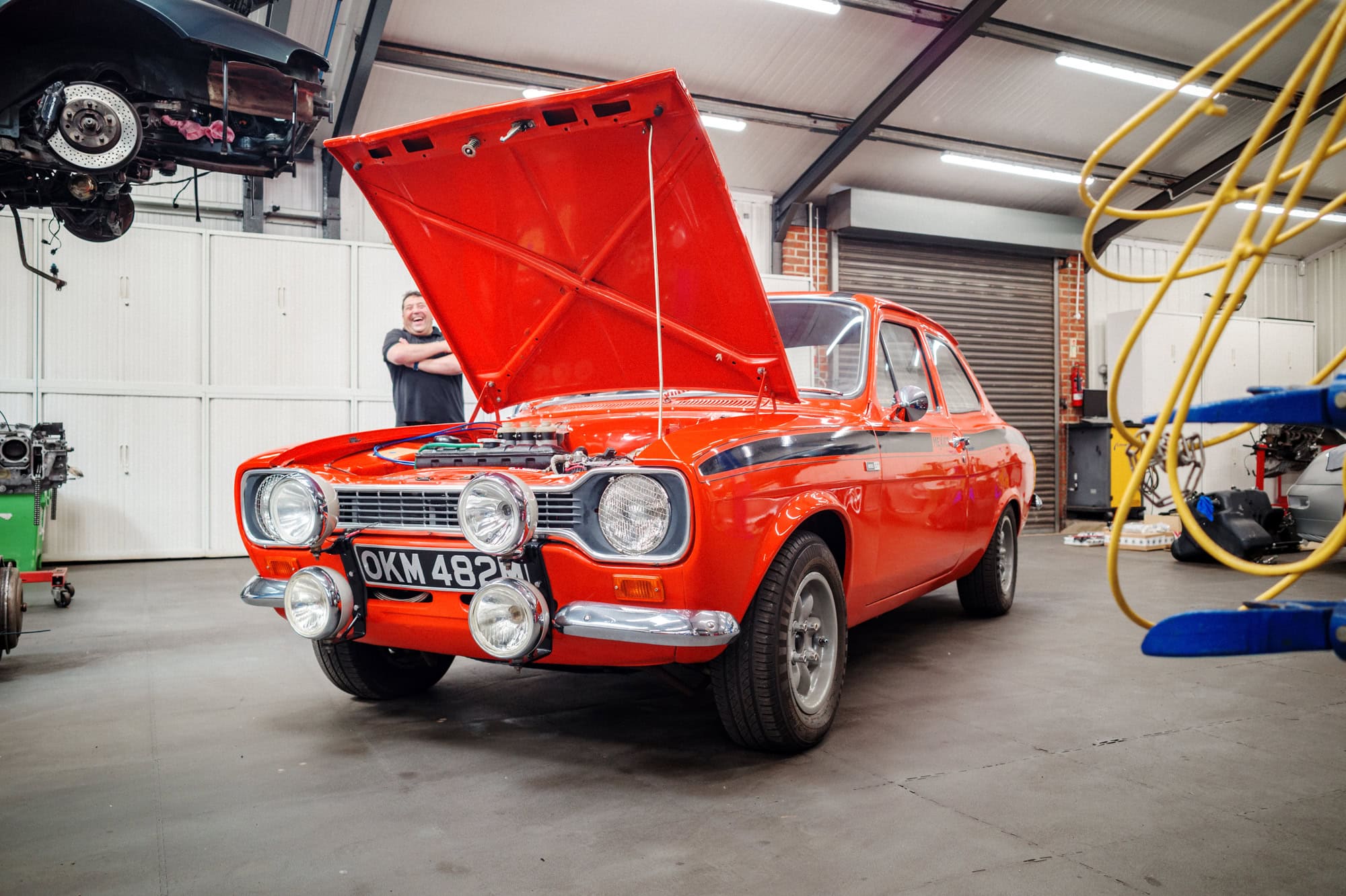 An orange Ford Escort Mexico mk1 at the hero motor company workshop.