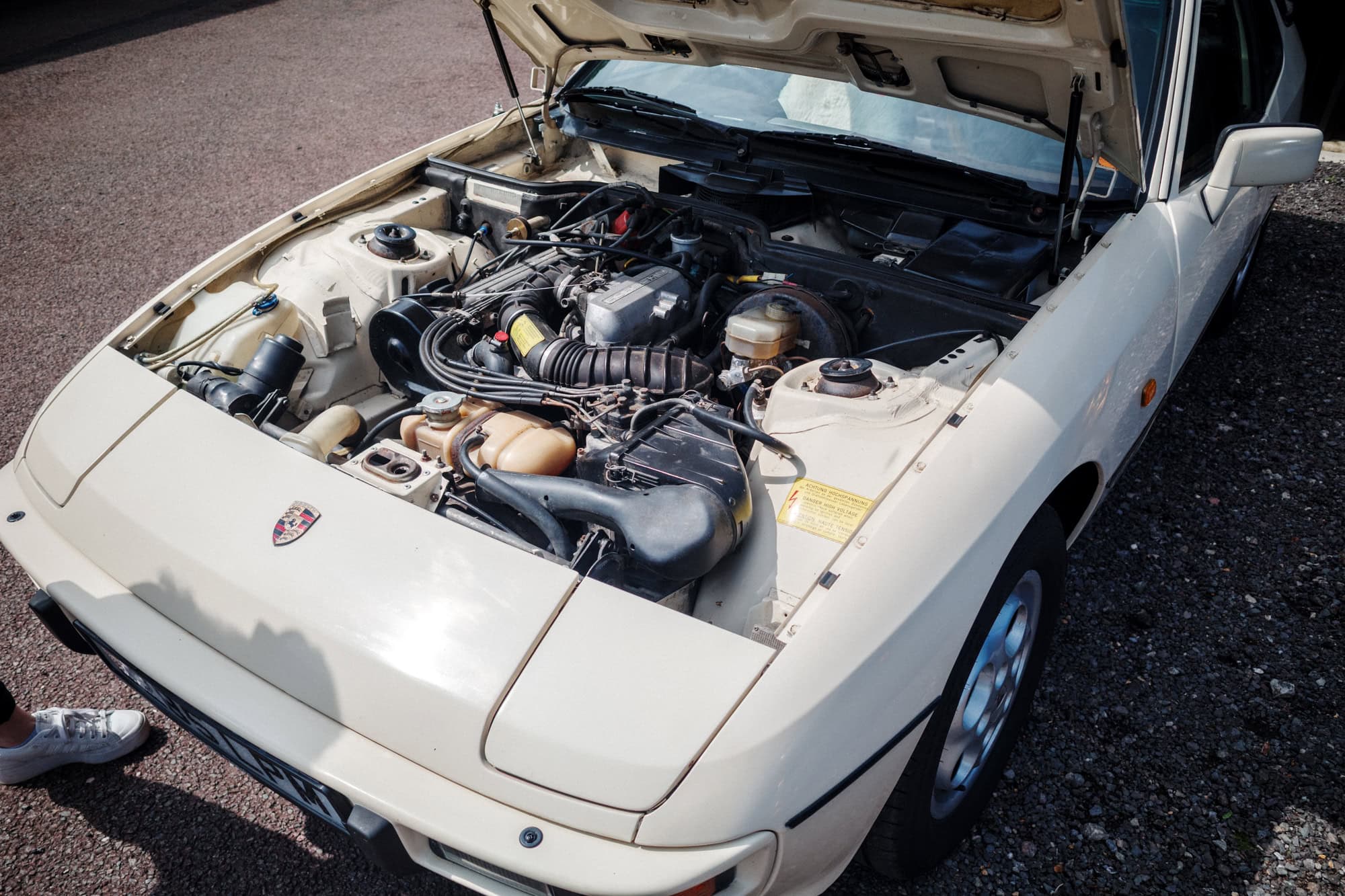 An engine bay of a beige Porsche 924.