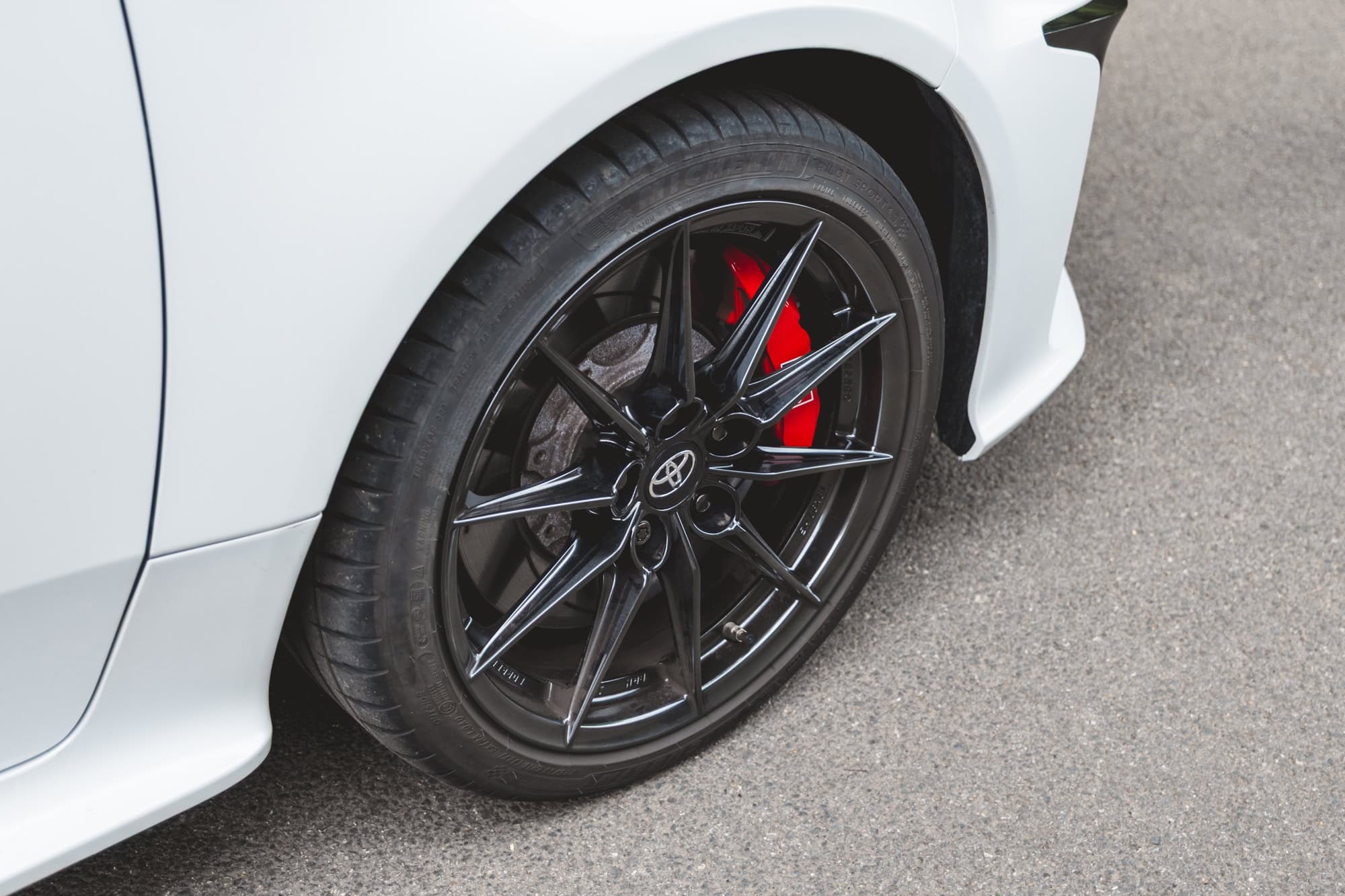 A close up of a black Toyota Yaris GR Four alloy wheel and brake caliper.