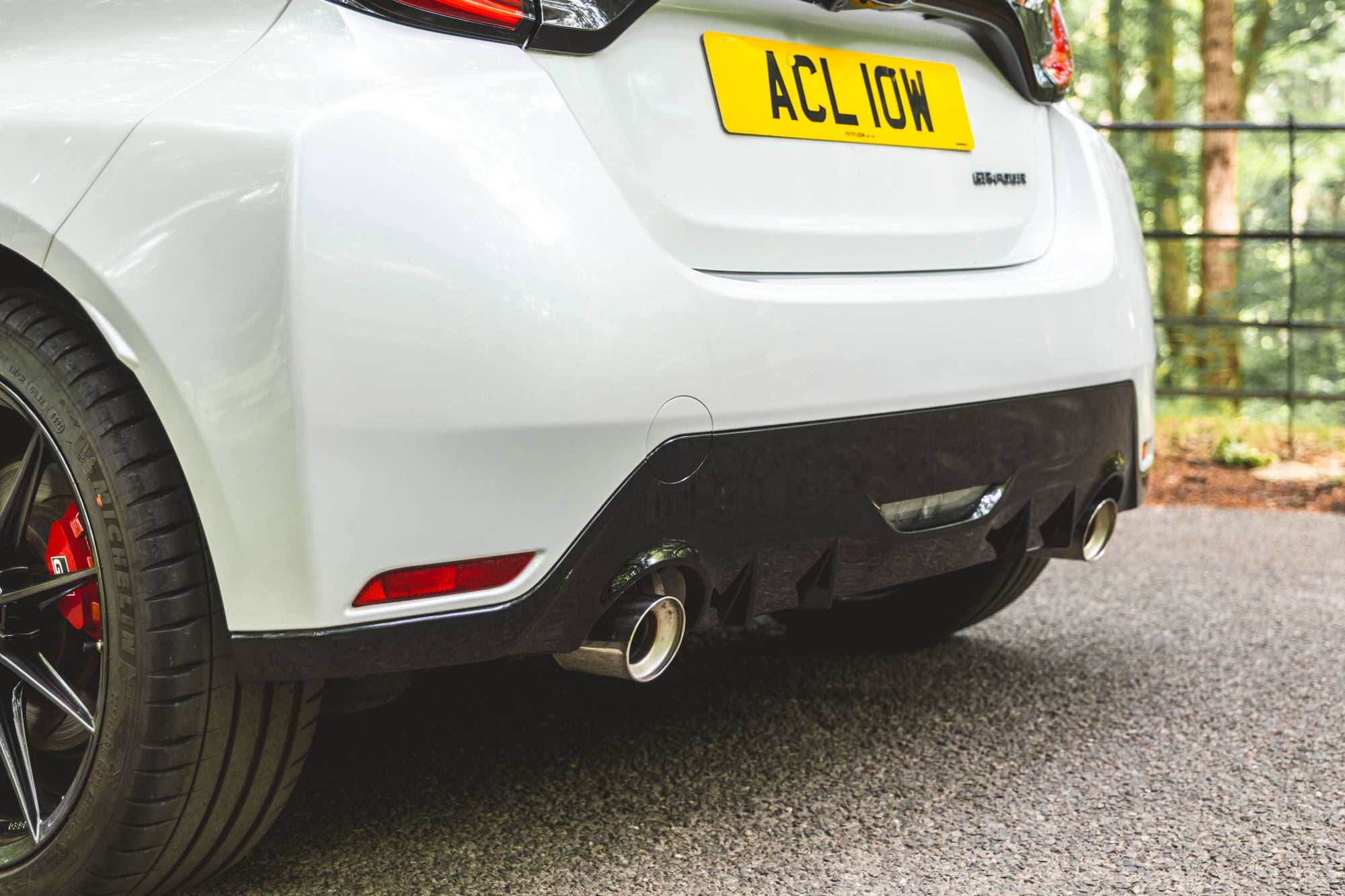 A close up of the exhaust pipes of a white Toyota Yaris GR Four.