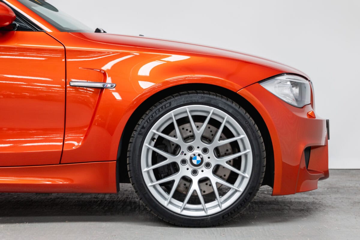 Close up of alloy wheel and front quarter on BMW E82 1M Coupe Valencia Orange