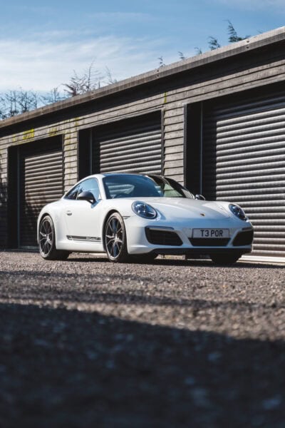 Luxury Porsche 911 Carrera T sports car parked outside Hero Motor Company showroom in the UK.