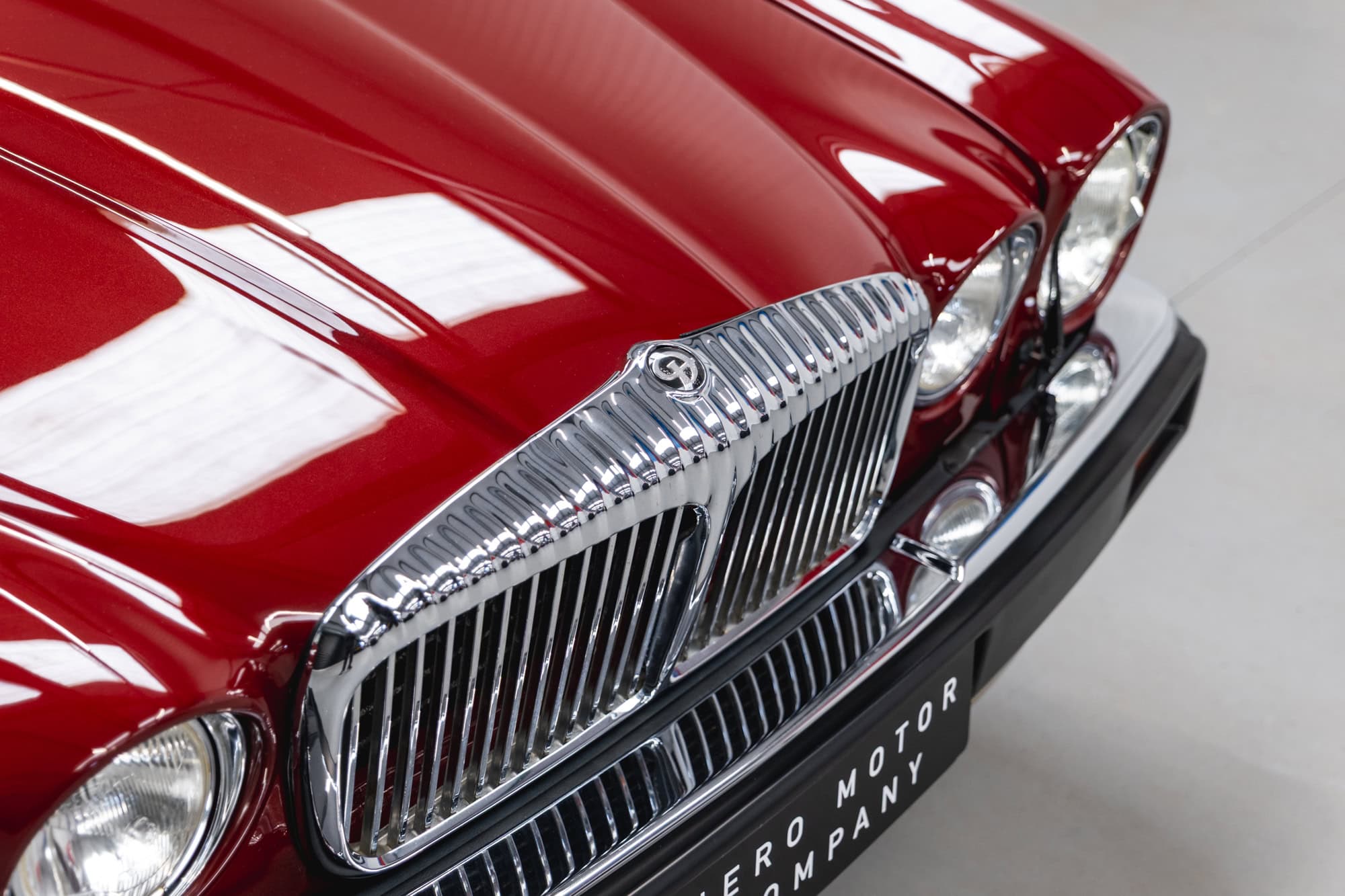 Close up of Daimler badge chrome trim and headlights on 985 Daimler Double Six Bordeaux Red Series 3 Saloon V12