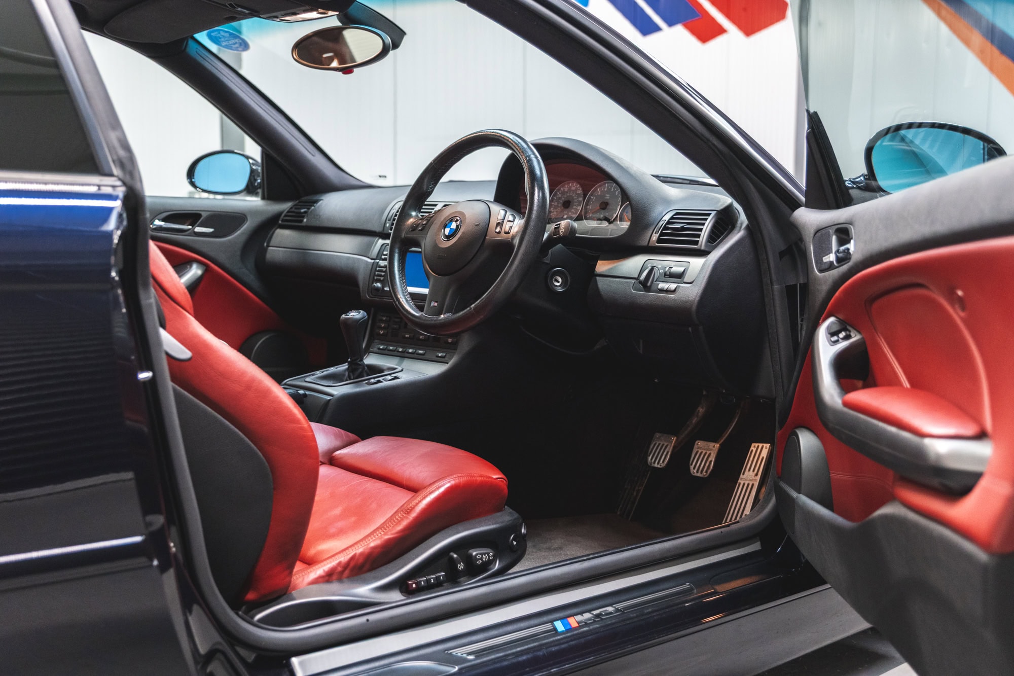 Offside view of red leather interior and centre console on BMW E46 M3 in carbon black with CSL alloy wheels and AP Racing brake Kit on Ohlins suspension with Karbonius CSL Carbon Airbox.