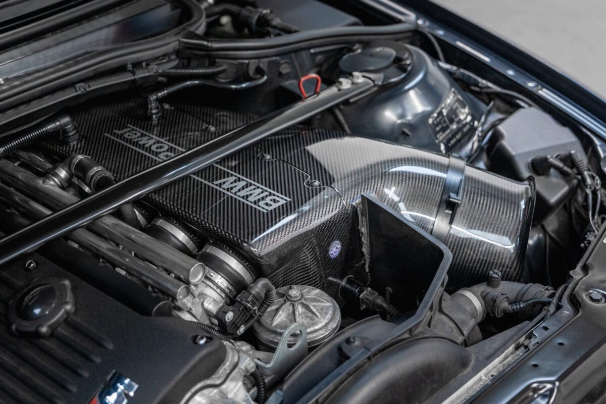 Close up view of the engine bay and airbox on a BMW E46 M3 in carbon black with CSL alloy wheels and AP Racing brake Kit on Ohlins suspension with Karbonius CSL Carbon Airbox.