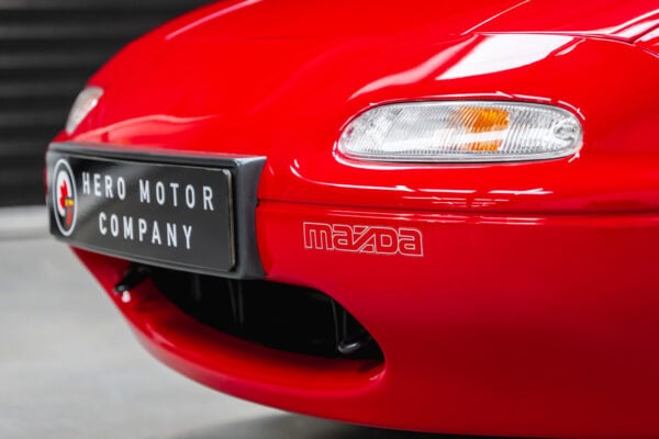 Close up view of headlight on Mazda MX5 MKI Classic Red Eunos Roadster