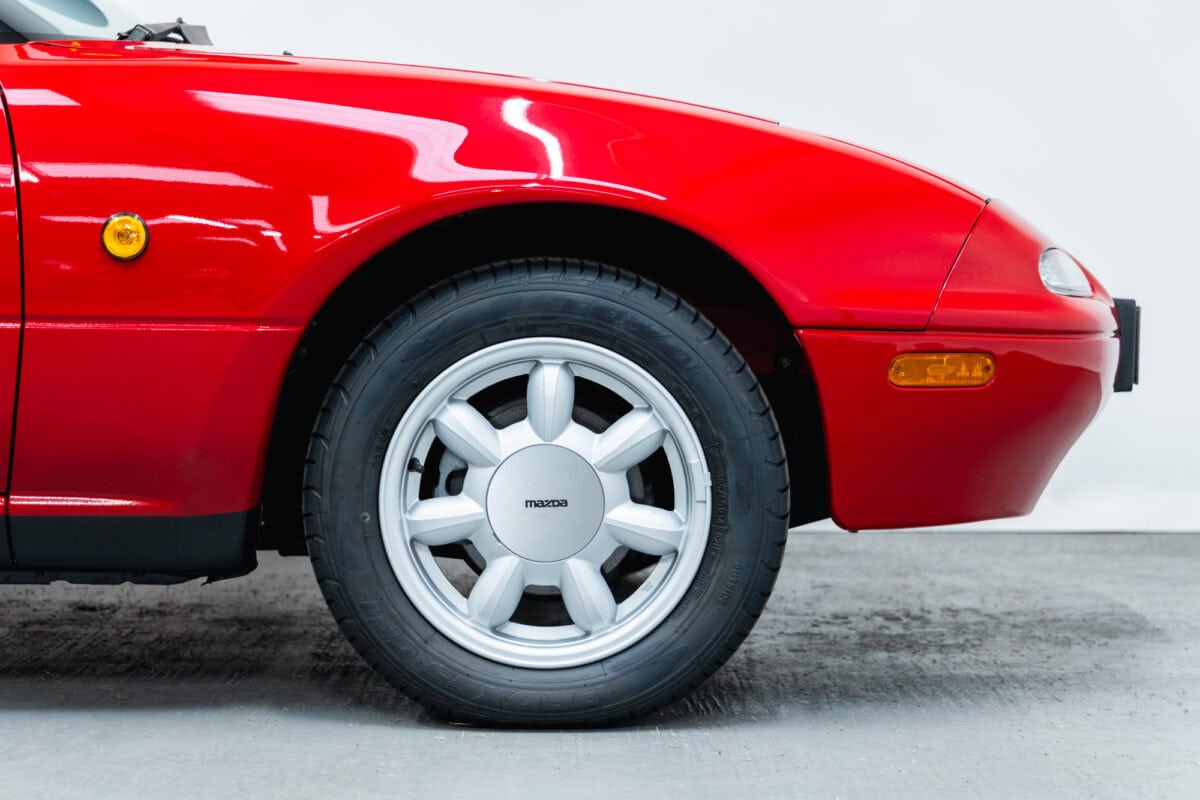 Front offside exterior wing close up of alloy wheel on Mazda MX5 MKI Classic Red Eunos Roadster