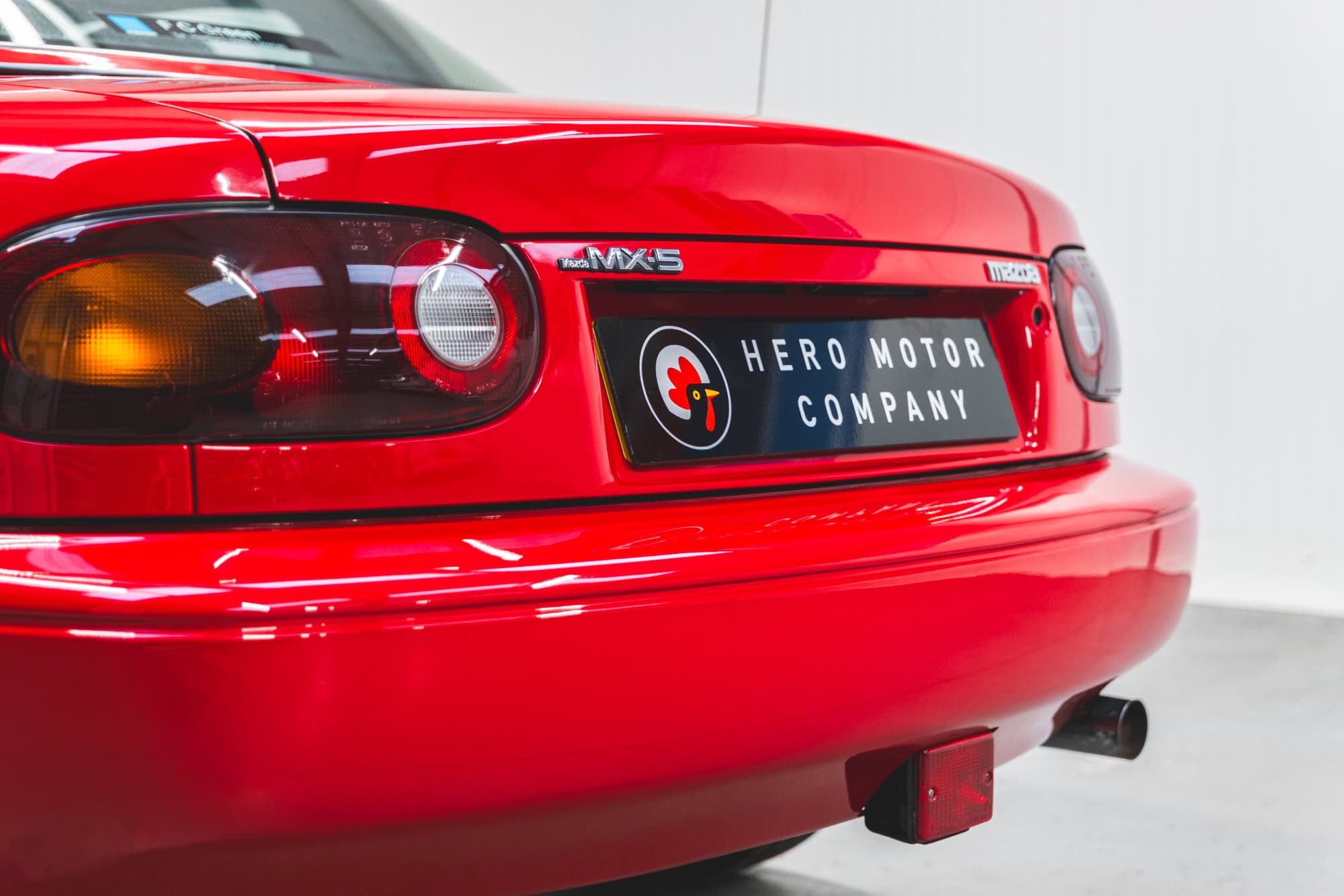Close up view of rear exterior tailpipe and rear lights on Mazda MX5 MKI Classic Red Eunos Roadster