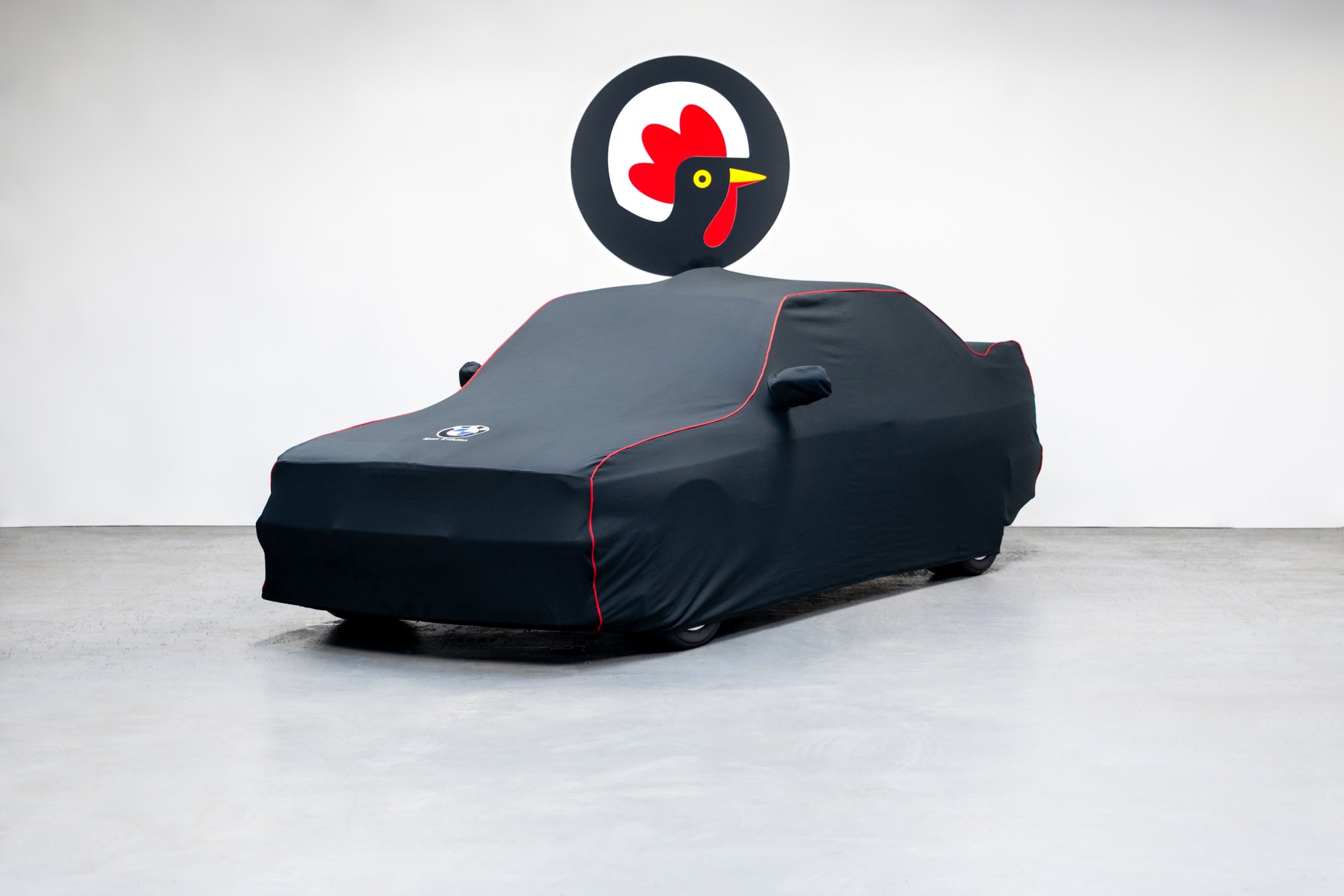 An E30 BMW M3 Sport Evolution for sale under a black car cover.