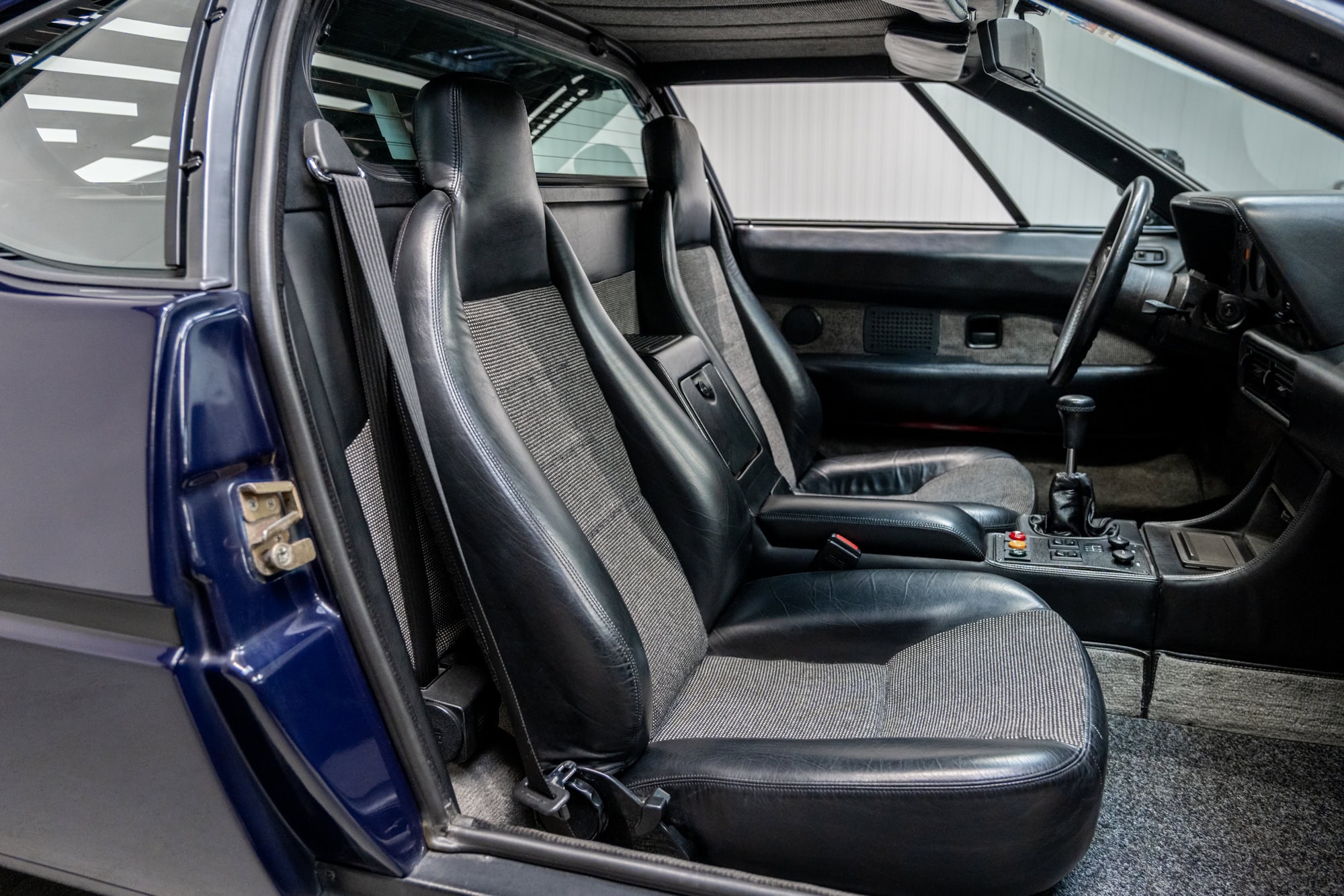 Offside view into the interior of a BMW E26 M1 1980 Nicht Blau showing seats headrests and steering wheel