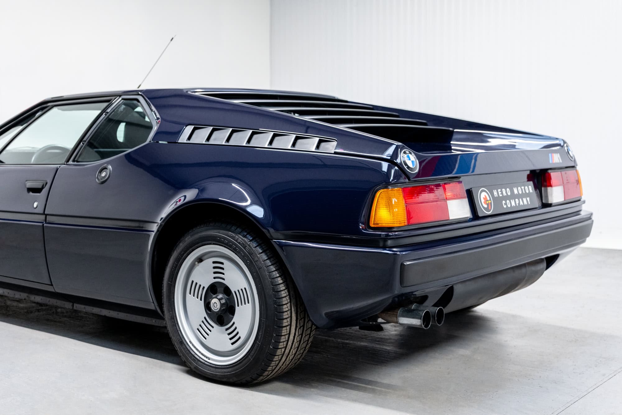 Nearside rear exterior of BMW E26 M1 1980 Nicht Blau showing tailpipes and alloy wheels
