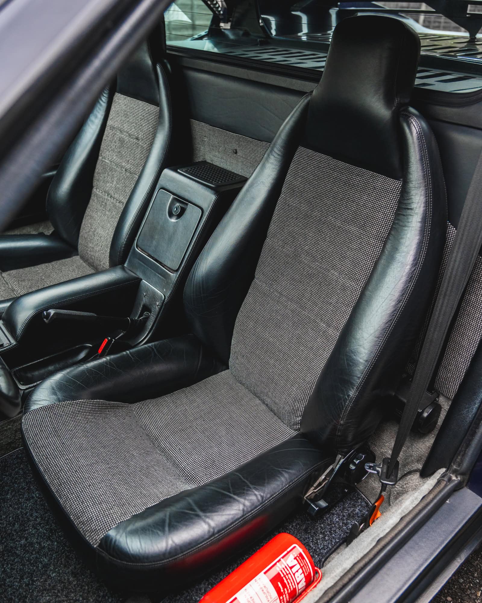 Nearside view of interior of 1980 E26 BMW M1 Nachtblau showing fire extinguisher