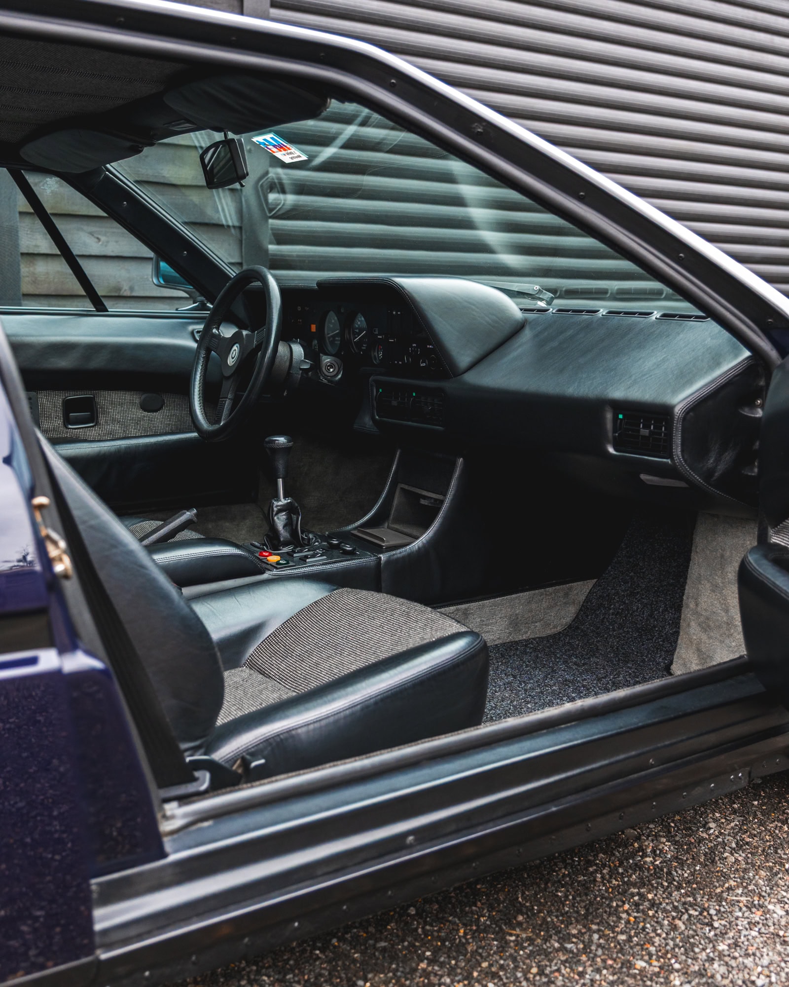 Offside view of interior 1980 E26 BMW M1 Nachtblau showing centre console steering wheels and gear stick