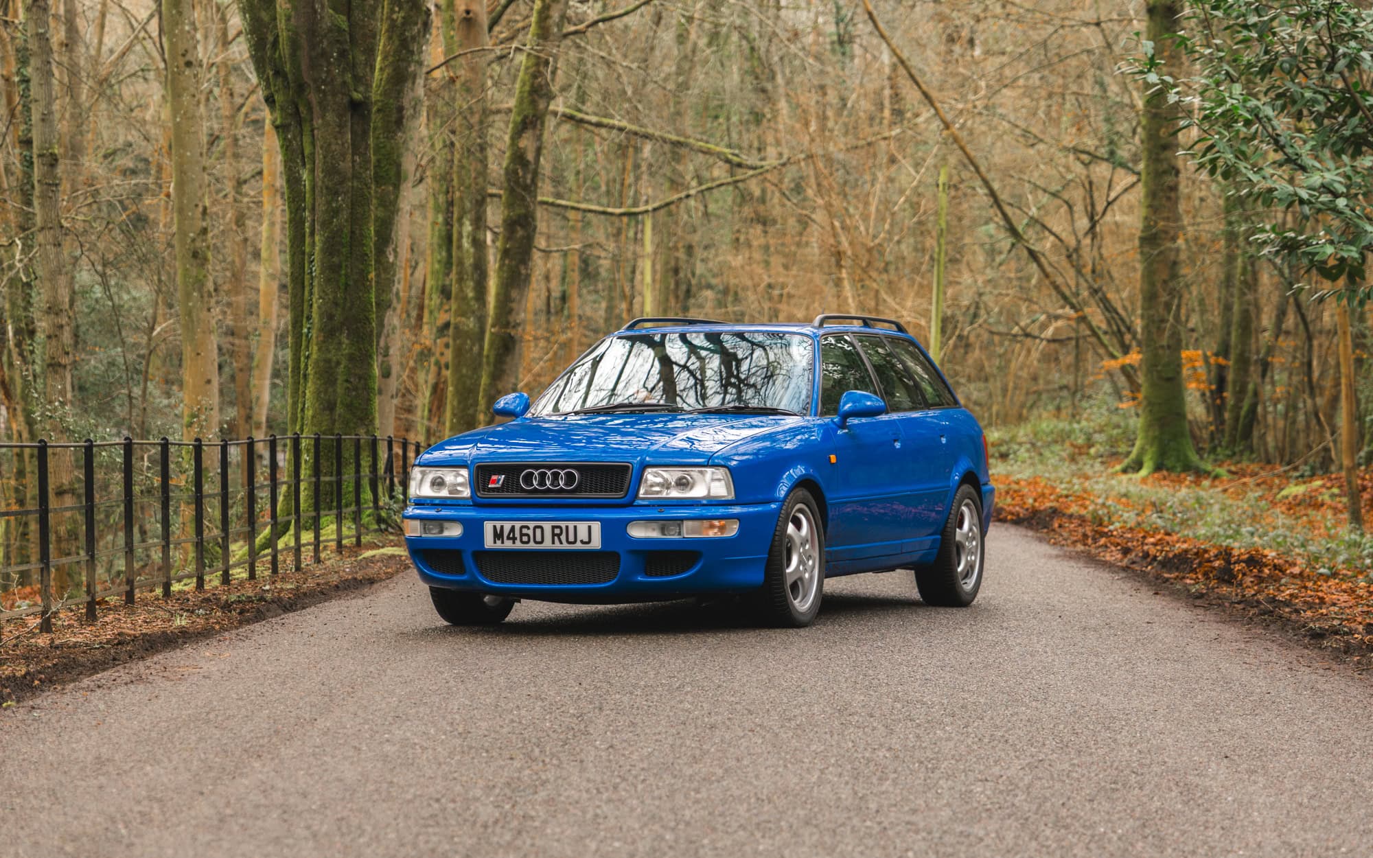 A blue Audi RS2 Avant on a forest road.