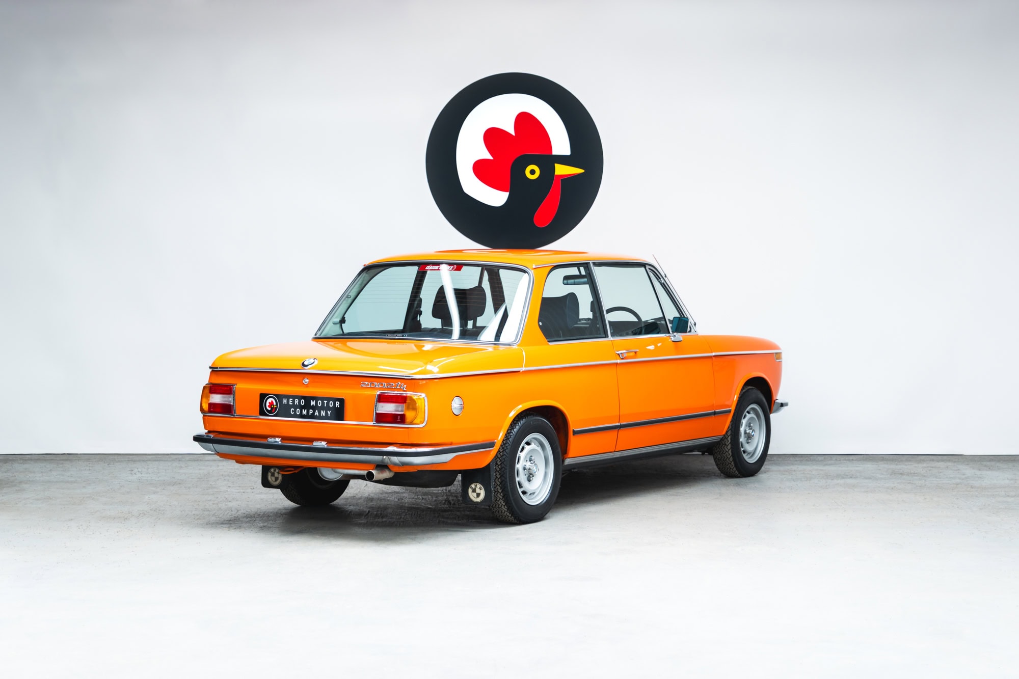 Offside rear quarter of a 1975 BMW 2002 tii in Inka Orange.